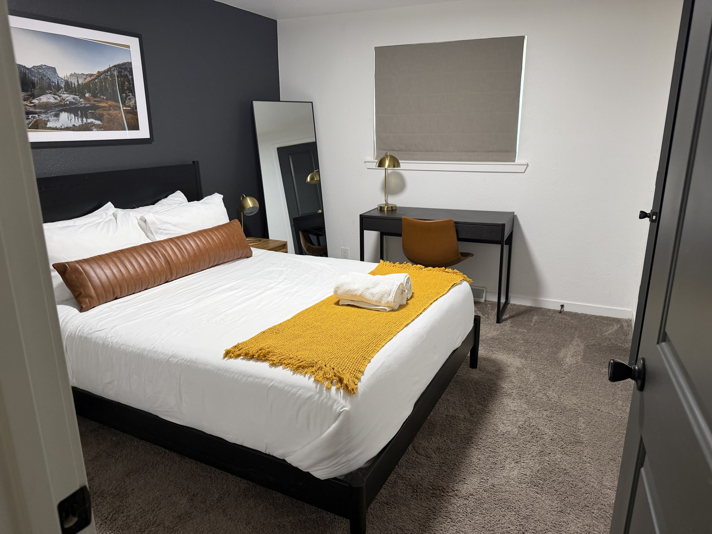 Clean bedroom with white bedding and gold accent pillow