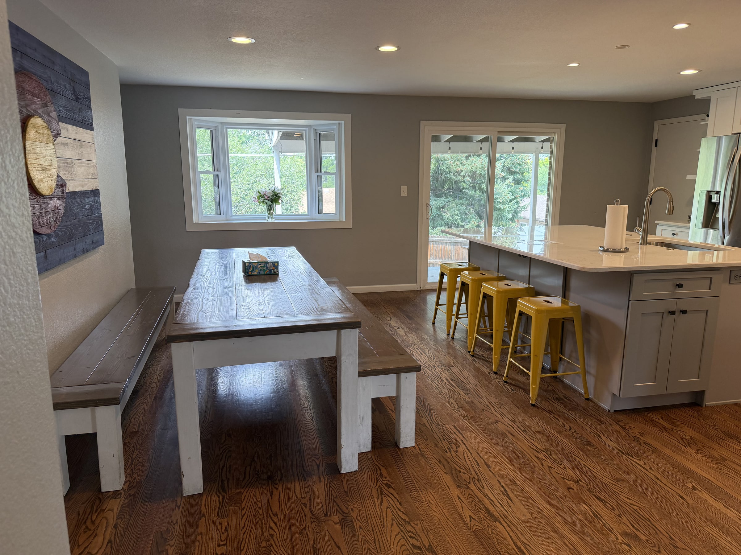 Clean dining table beside a bright kitchen island