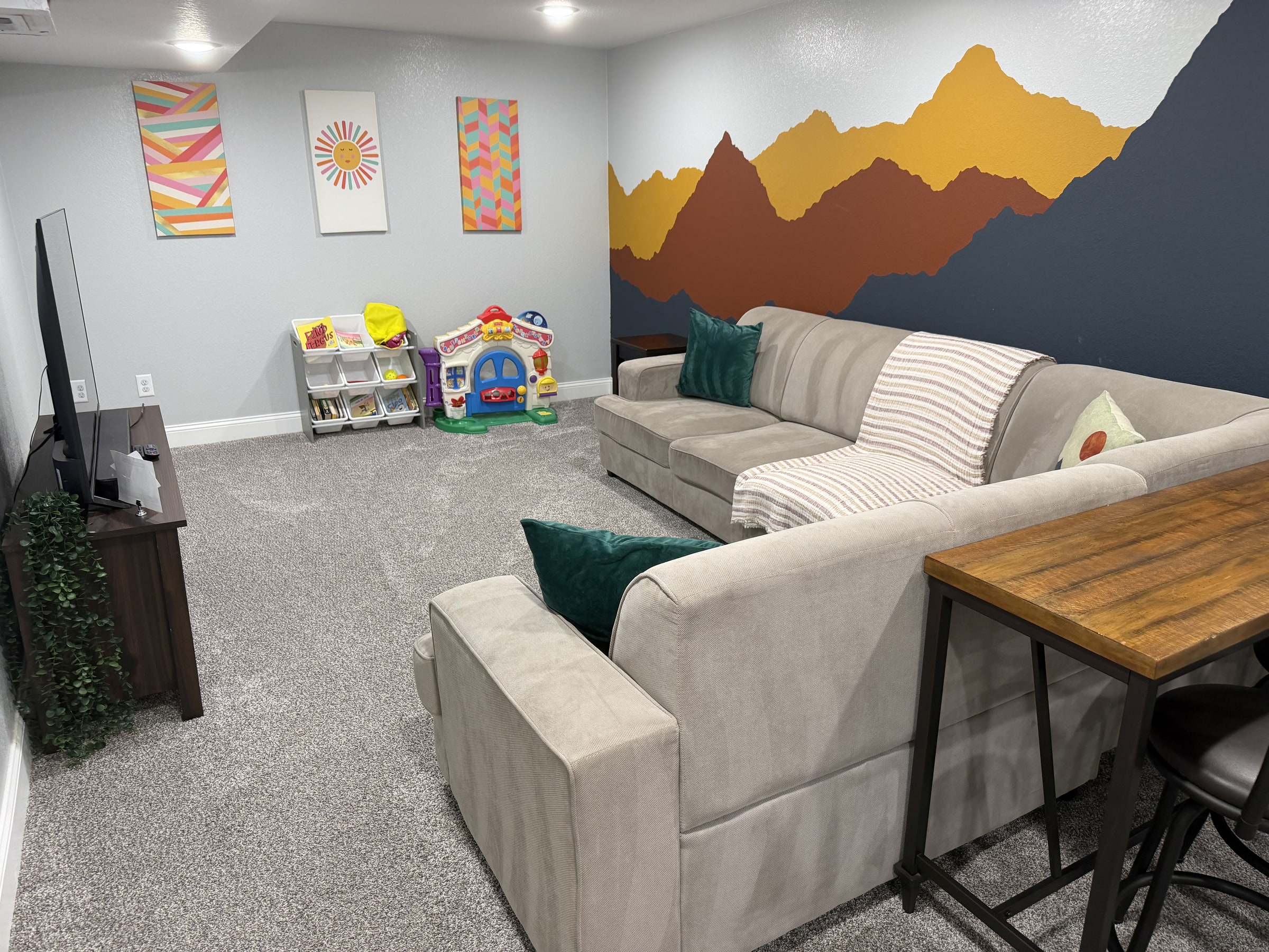 Guest lounge with white sofa, mountain wall art, and clean carpet