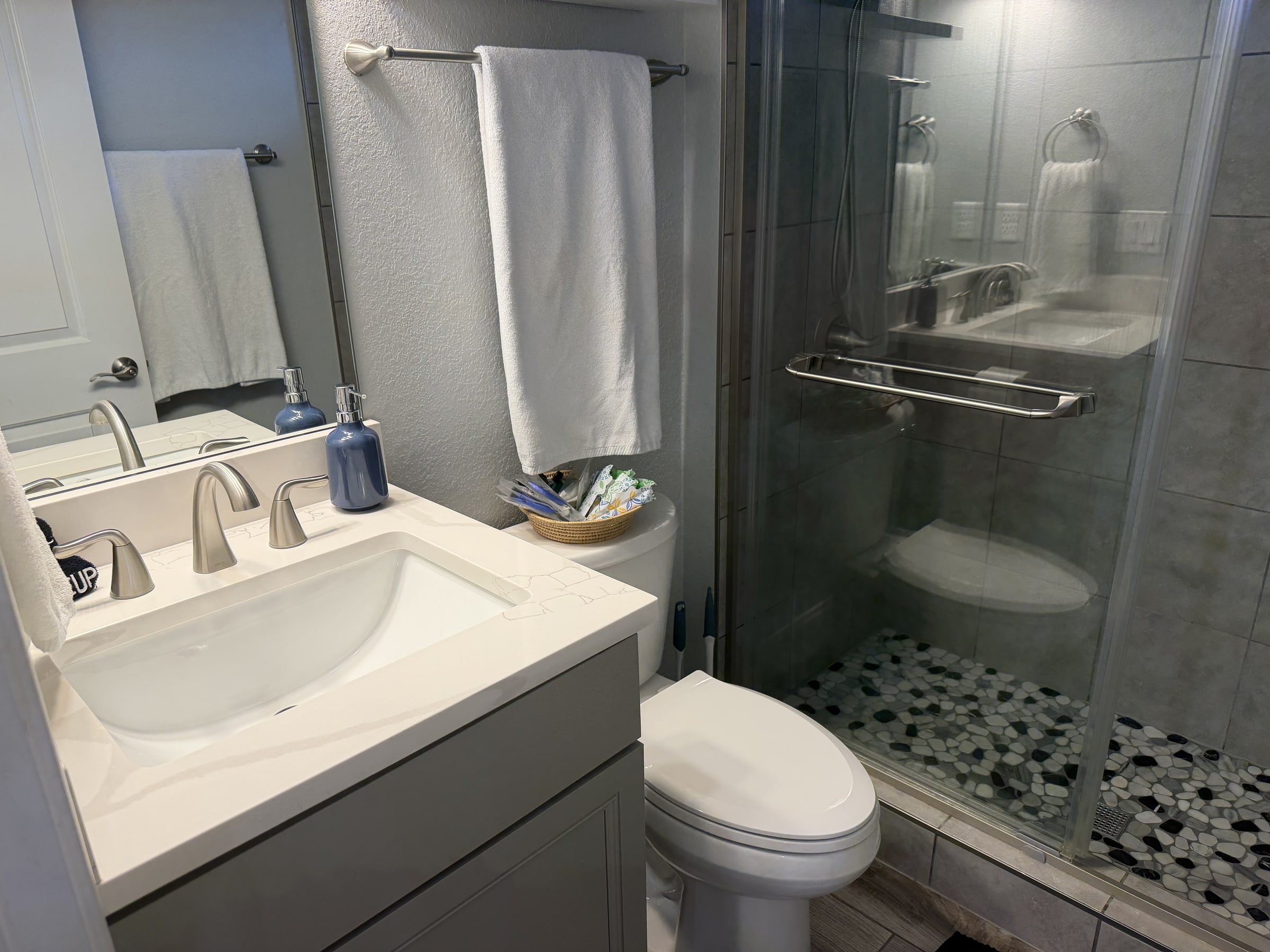Clean bathroom with glass shower, vanity, and fresh towels